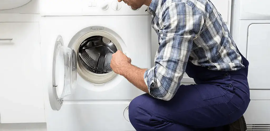 Handyman inspecting a dryer drum and internal parts for repair in Pueblo, CO