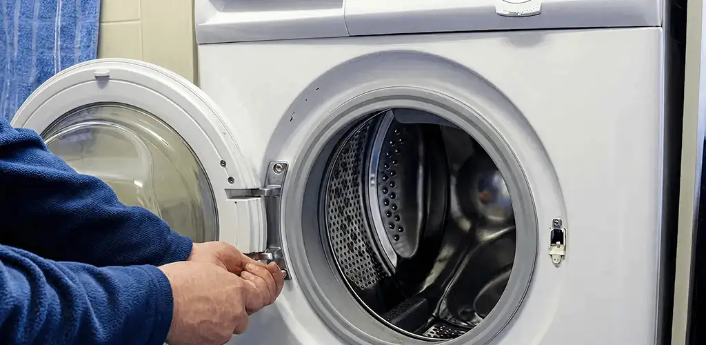 Washing machine repair handyman checking a front-load washer door and latch in Pueblo, CO