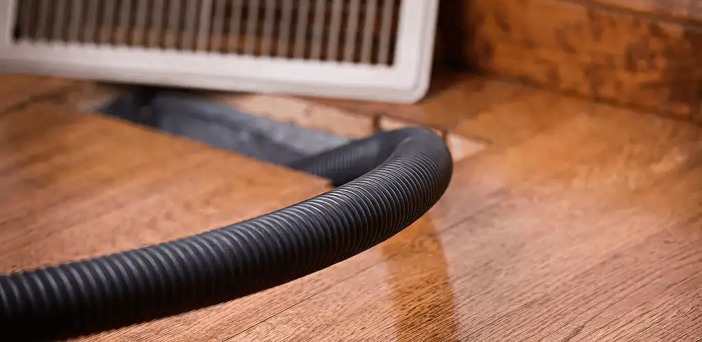 Air duct cleaning hose inserted into a floor vent for ductwork cleaning in Pueblo, CO
